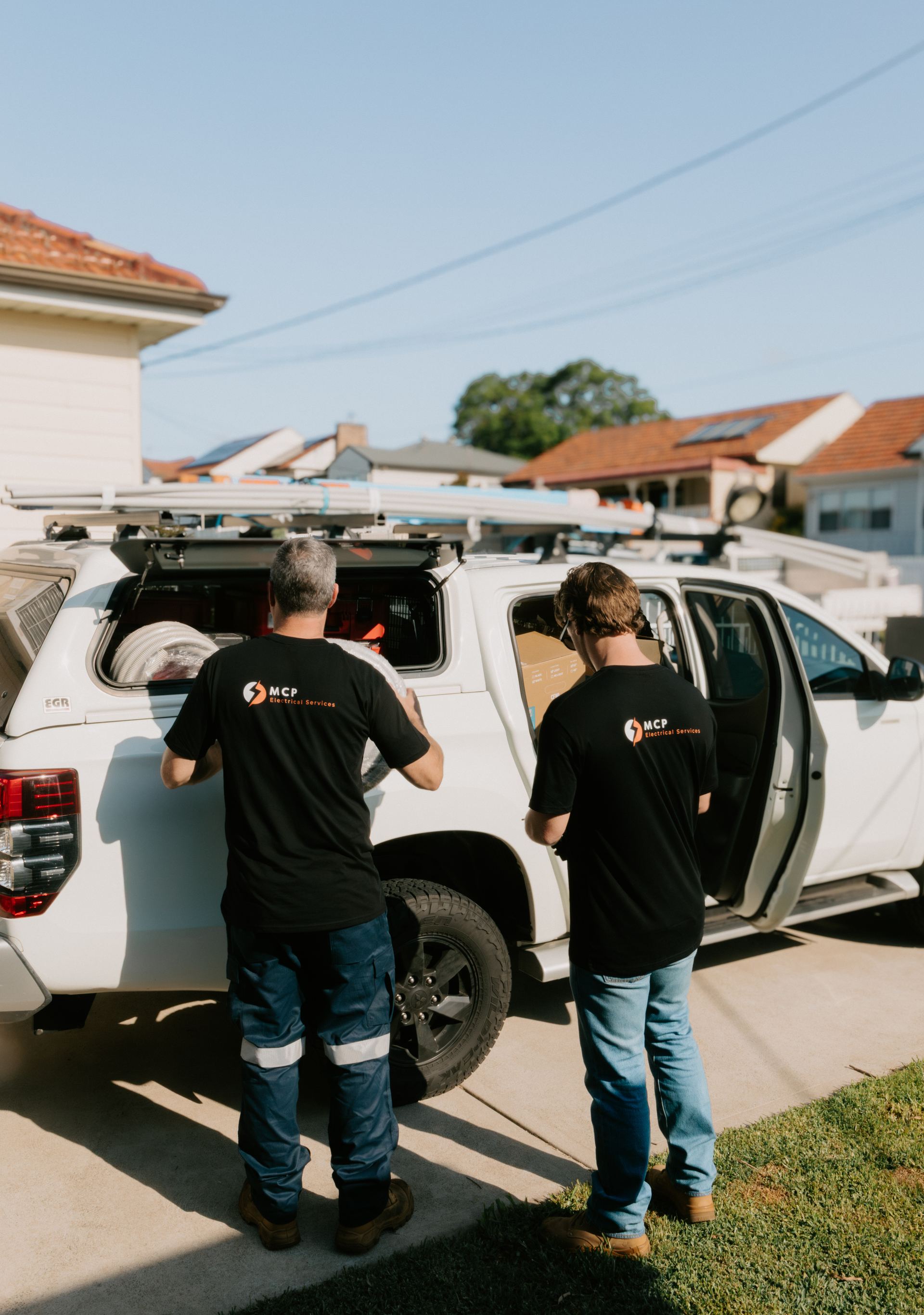 MCP Electrical Services electricians loading equipment from the work van before a Newcastle job